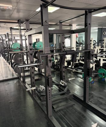 Zona de peso libre equipada con rack robusto y barras especializadas ATX para entrenamiento de potencia.
